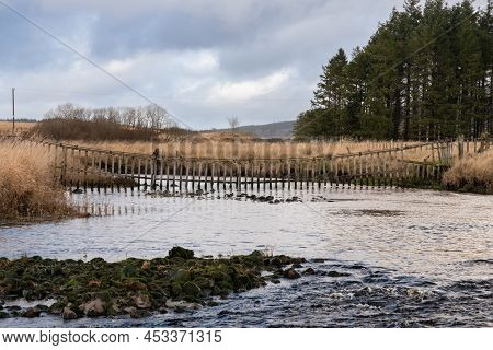 A Watergate Hanging Across The Carsphairn Lane River At The Confluence With The Water Of Deugh In Wi