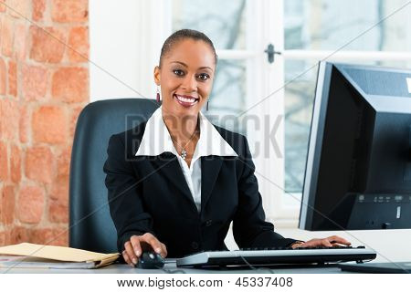 Giovane donna avvocato o paralegal lavorando nel suo ufficio su un Computer o un Pc