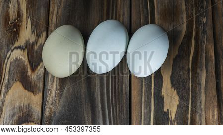 Araucana Eggs On Wooden Background. Three Light Blue Eggs From Araucana Chicken. Easter Festival Con
