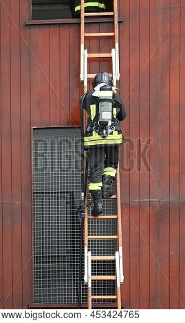 Firefighters In Action In The Fire Station With Self-contained Breathing Apparatus And Oxygen Tanks 