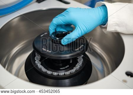 Female Lab Technician In Rubber Gloves Refills A Centrifuge And Close The Cap. Dna Test Or Onglogy M