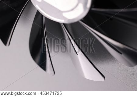 Close-up Of Cooling Fan With Black Plastic Blades On Grey Background. Car Details Parts. Device For 