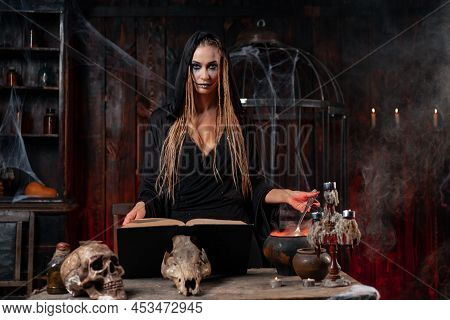 Halloween, Witch Use Magic Book And Cauldron Prepare Poison Or Love Potion. Black Magic Occult Femal