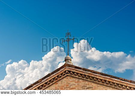 Close-up Of A Wrought Iron Religious Cross Against A Clear Blue Sky With Clouds And Copy Space. Trev