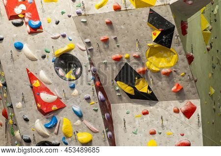 Artificial Rock Climbing Wall With Various Colored Grips.