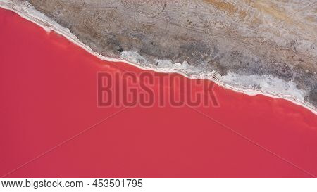 Flying Over A Pink Salt Lake. Salt Production Facilities Saline Evaporation Pond Fields In The Salty