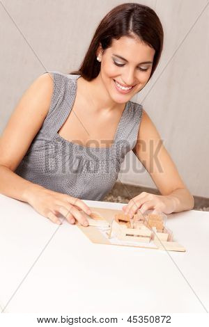 En kvindelig arkitekt designe en skala model hus