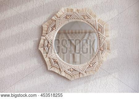 Macrame Mirror On A White Wall.  The Mirror Reflects Macrame Wallhanging. Eco-style. Natural Materia