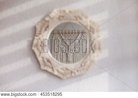 Macrame Mirror On A White Wall.  The Mirror Reflects Macrame Wallhanging. Eco-style. Natural Materia