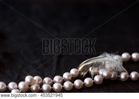 Feminine Desktop Mockup With Pearls And Feather On Black Paper Background With Copyspace.
