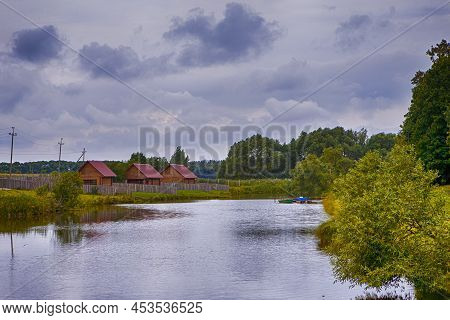 Belarus Travel Places. Tiny Pier And Line Of Wooden Houses Places Together In Dukora Estate In Belar