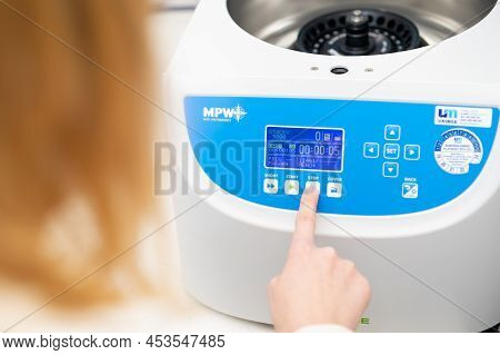 Woman Sets Parameters On The Centrifuge For Sample Preparation. Dna, Oncology Marker Analysis In Cli