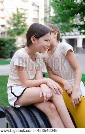 Kids Outdoors Having Fun On Modern Playground With New Colorful Equipment. Sisterhood, Friendship. T