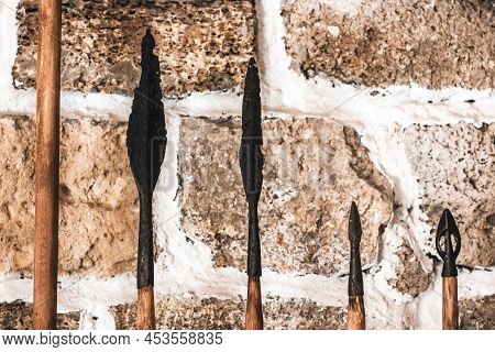 Spearheads. Old Spears On The Background Of The Wall. Spear Tips.\nold Things