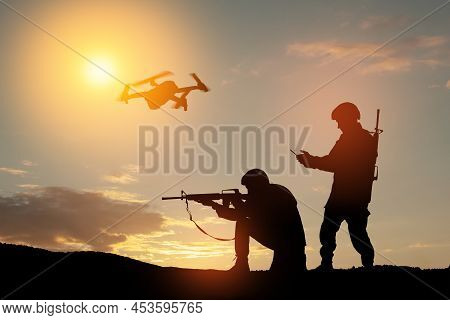 Silhouettes Of Soldiers Are Using Drone And Laptop Computer For Scouting During Military Operation.