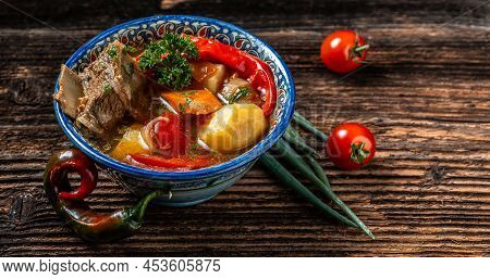 Shurpa Soup In Plate With Oriental Ornament, Wooden Background. Top View. Traditional Asian, Uzbek, 