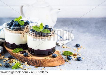 Parfait With Blueberry, Granola And Jam In Two Glass Jars. Healthy Dessert Or Snack.