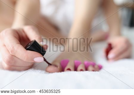 Close-up Of Female Doing Pedicure At Home, Beauty Day. Woman Painting Toenails. Nail Polish And Beau