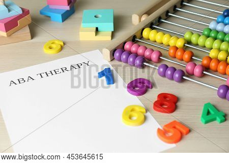 Paper Sheet With Abbreviation Aba (applied Behavior Analysis), Abacus And Colorful Numbers On White 