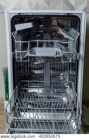 Wide Open Dishwasher. Racks And Dishwasher Containers.