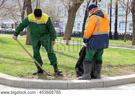 Moscow, Russia - April 2022: Two Workers Clean The Lawns In Spring Park. City Improvement, Janitors 