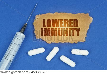 Medical Concept. On A Blue Surface Lie A Syringe, Pills And A Cardboard Sign With The Inscription - 