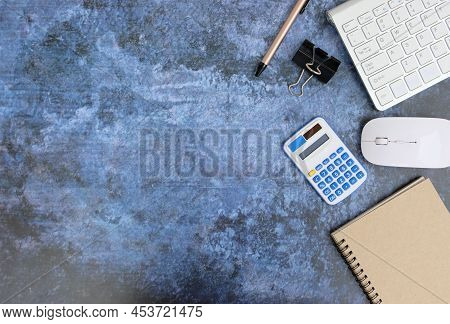 Blank Notebook Is In The Middle Of Office Desktable With Pen And Office Supplies. Top View, Flat Lay