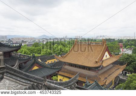 Looking Out Over The Roof Tops Of The Jinshan Temple With The City Of Zhenjiang In The Background On