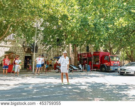 Omis, Croatia - August 12 2013: Woman In White Outfit Stands On Street Regulating Traffic In Omis. C
