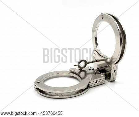 Isolated Photo Of Closed Police Handcuffs On A White Background With The Key In Place Ii Copia