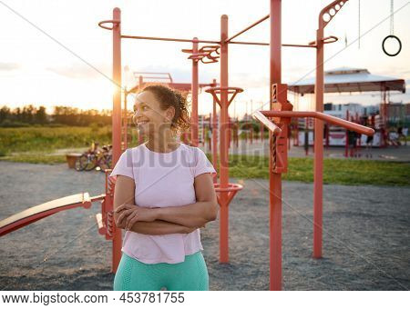 Confident Portrait Of A Pleasant Middle Aged Athletic Woman In Sportswear Smiling And Looking Aside,