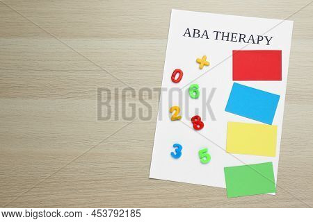 Phrase Aba Therapy And Different Colors With Numbers On White Wooden Table, Top View. Space For Text