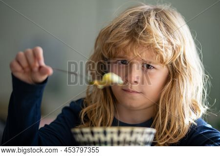 Close Up Portrait Of Funny Kid Eating. Sad Boy Eating Healthy Chicken Noodle Soup For Lunch. Unhappy