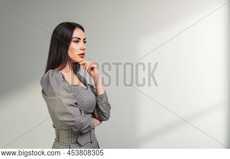 Young Attractive Businesswoman Wearing Formal Wear Is Standing Touching Chin In Cross Arm Pose Near 