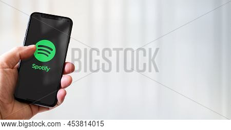 Paris - France - March 15, 2022 : Hand Holding Iphone Smartphone With Spotify Logo. Horizontal Banne