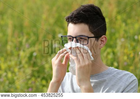 Guy With Glasses Sneezing On A White Handkerchief Because He Is Allergic To Weeds