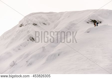 Great View Of Large Snow-capped Mountain With Group Of People Rising To The Top