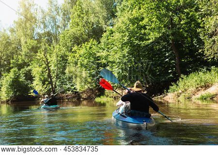 Family Kayak Trip. Man And Woman And Elderly Couple Senior And Seniora Rowing Boat On The River, A W