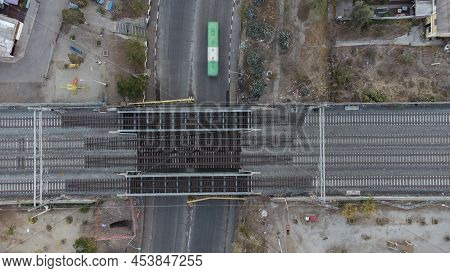 Micribus Driving Under A Railway Bridge. Aerial View Of A Railway Bridge In A Low Level Crossing Whi
