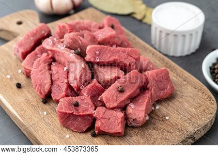 Chopped Topside Meat On Wooden Board  Over Stone Background With Seasonings.