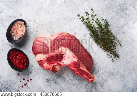 Raw Beef Meat. Rough Piece Of Meat On Bone For Roast Or Soup With Salt, Pepper, Thyme And Rosemary O
