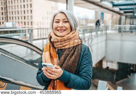 Senior Woman Send Message With A Mobile Phone In A Stransport Station