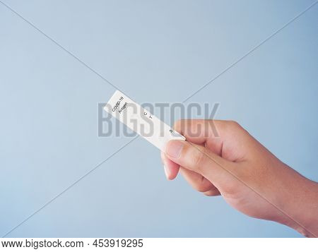 Human Hand Holding Empty Atk Or Antigent Test Kit For Covid-19 Over Blue Background.
