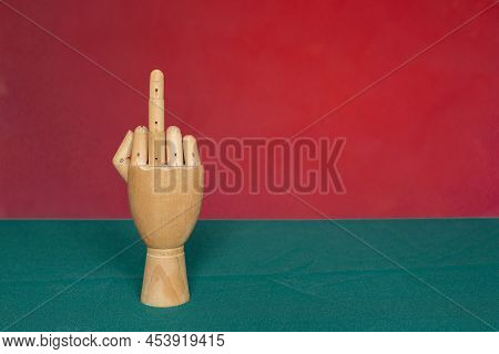 Wooden Hand With Middle Finger On Red-green Background