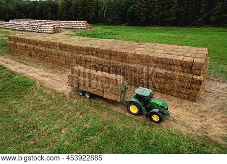 John Deere Tractor With Straw Hay Trailer The Transporting Round Bales. Storage Hay At Farm. Hay For