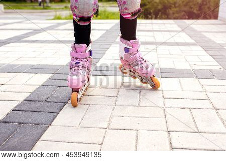 The Girl Rides On Pink Roller Skates With A View Of Her Legs. Part Of The Body In The Form Of Legs W