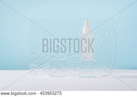 Serum Cosmetic Bottle With Peptides And Retinol On Acrylic Blocks On Blue Background. Hyaluronic Aci
