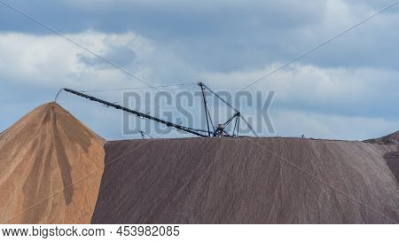 Giant Spreader Or Absetzer Machinery. A Large Dumper On A Landfill With Potash Ore. Extracting And M