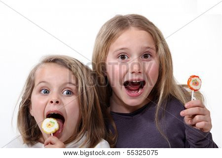 Little girls with lollipops