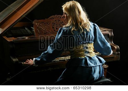 Baroque woman playing on an old grand piano